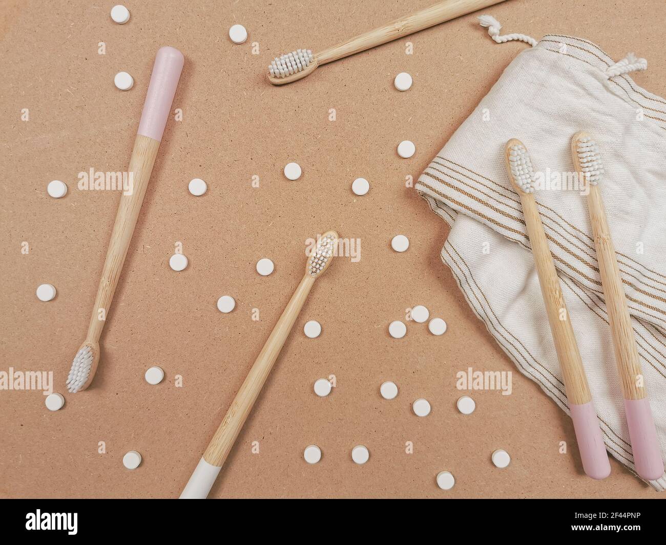 Bamboo toothbrush and dental tabs on a wooden background as a plastic free swap. Zero waste personal care products. Stock Photo