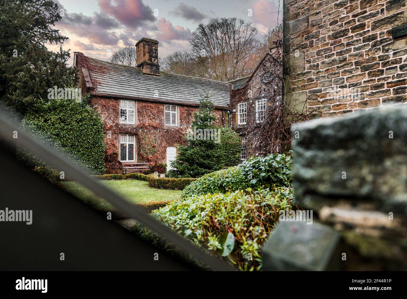Whitley Hall Sheffield old stone cottage accommodation with Christmas tree and lights in romantic winter garden courtyard Stock Photo