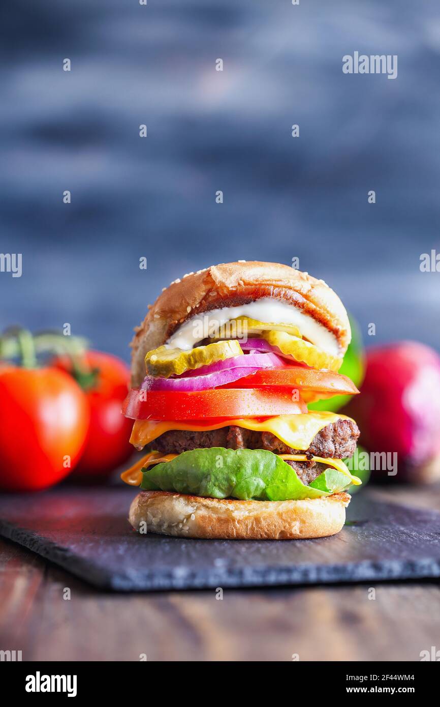 A big, fat, juicy double cheeseburger made with two 100% beef patties, slices of melted cheese, onions, pickles, lettuce, tomatoes, and mayo. Stock Photo