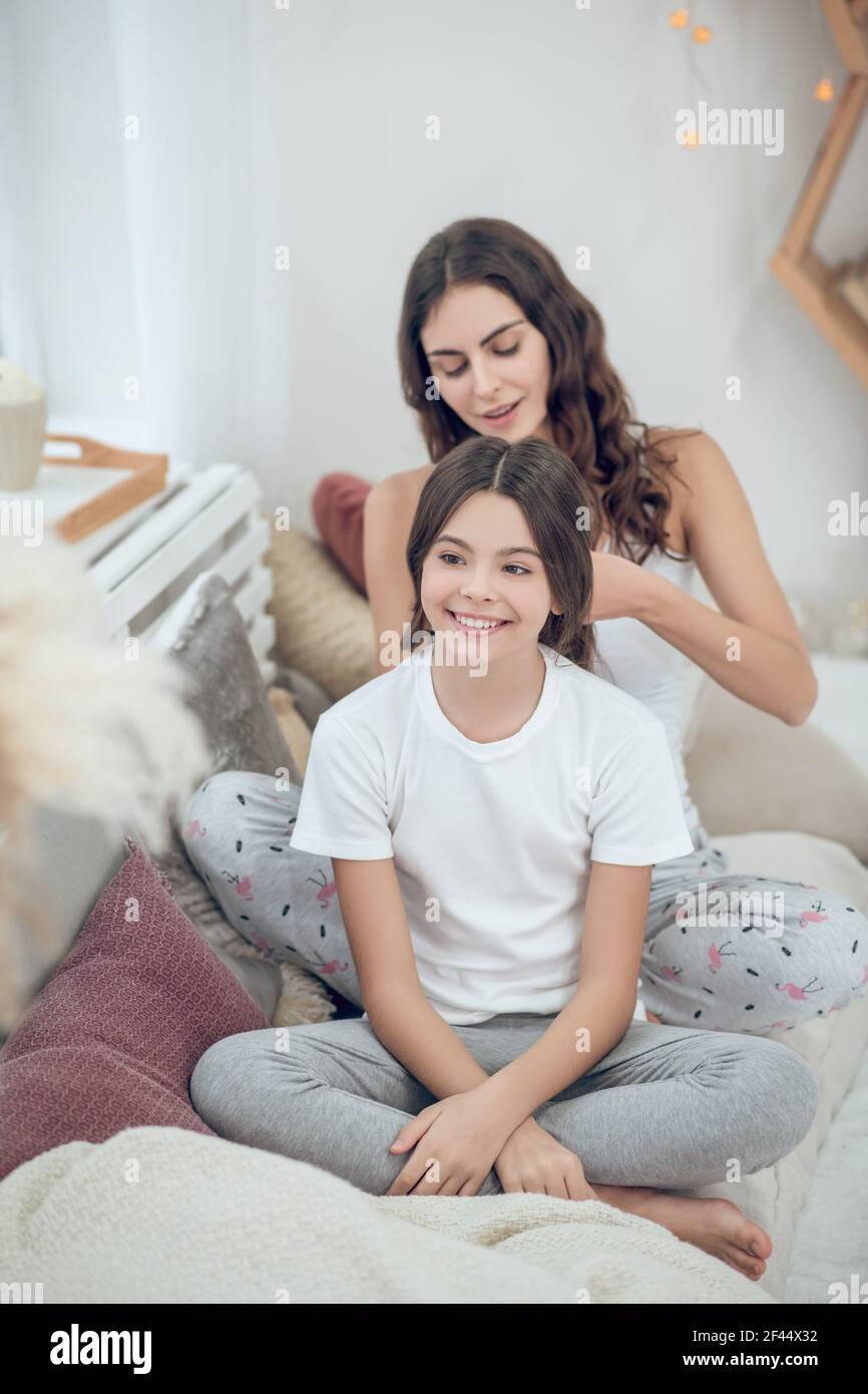 Joyful girl and woman doing her hair Stock Photo