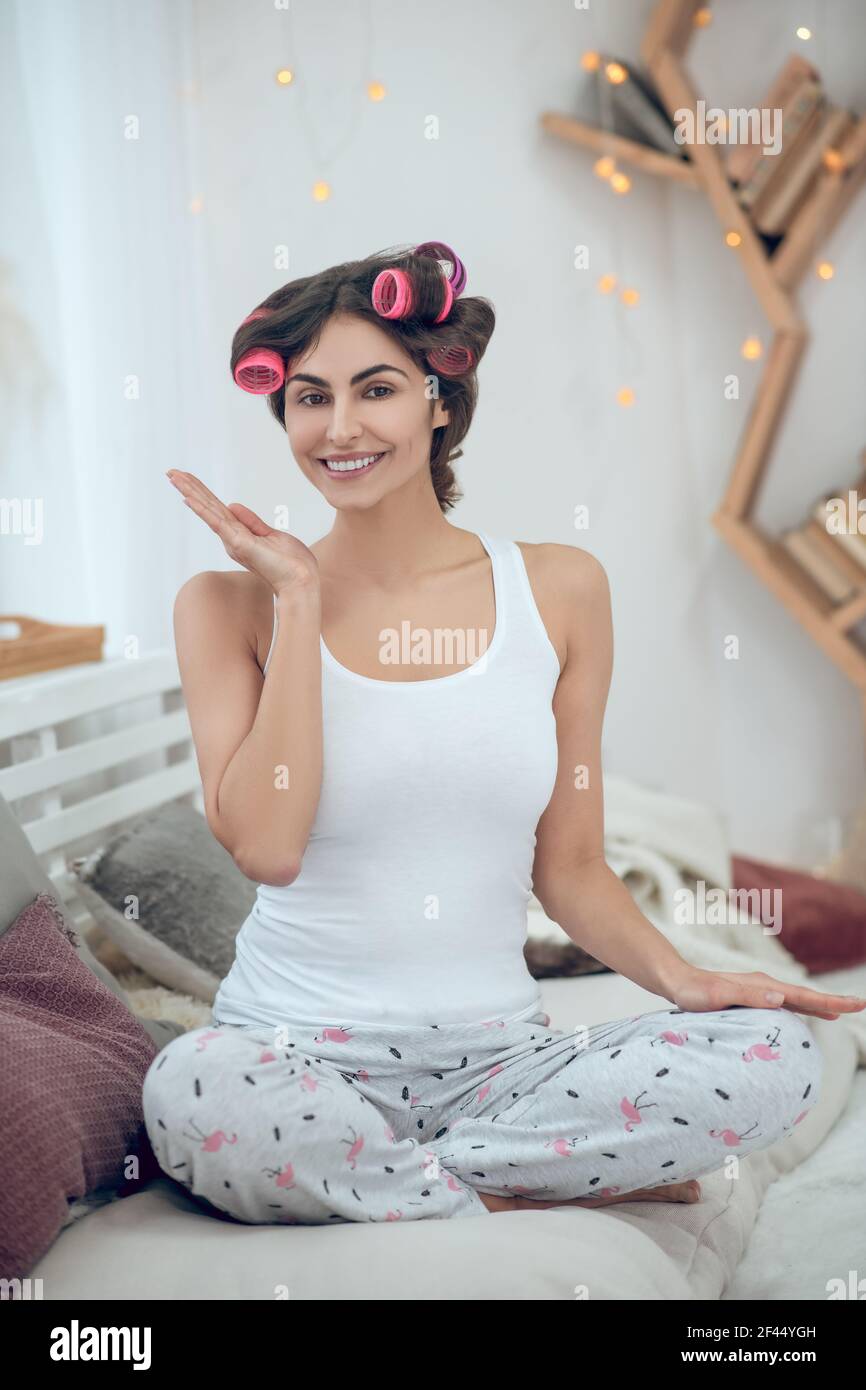Young woman sitting with curlers on her hair Stock Photo