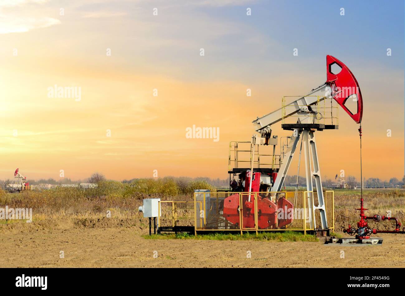 Crude oil pump jack at oilfield on atmospheric sunset backround. Fossil