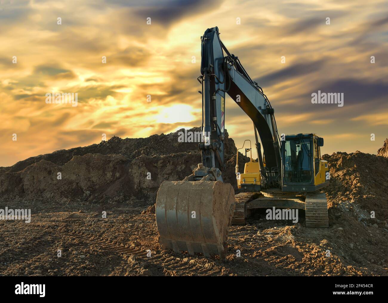 Excavator working on earthmoving at open pit mining on sunset