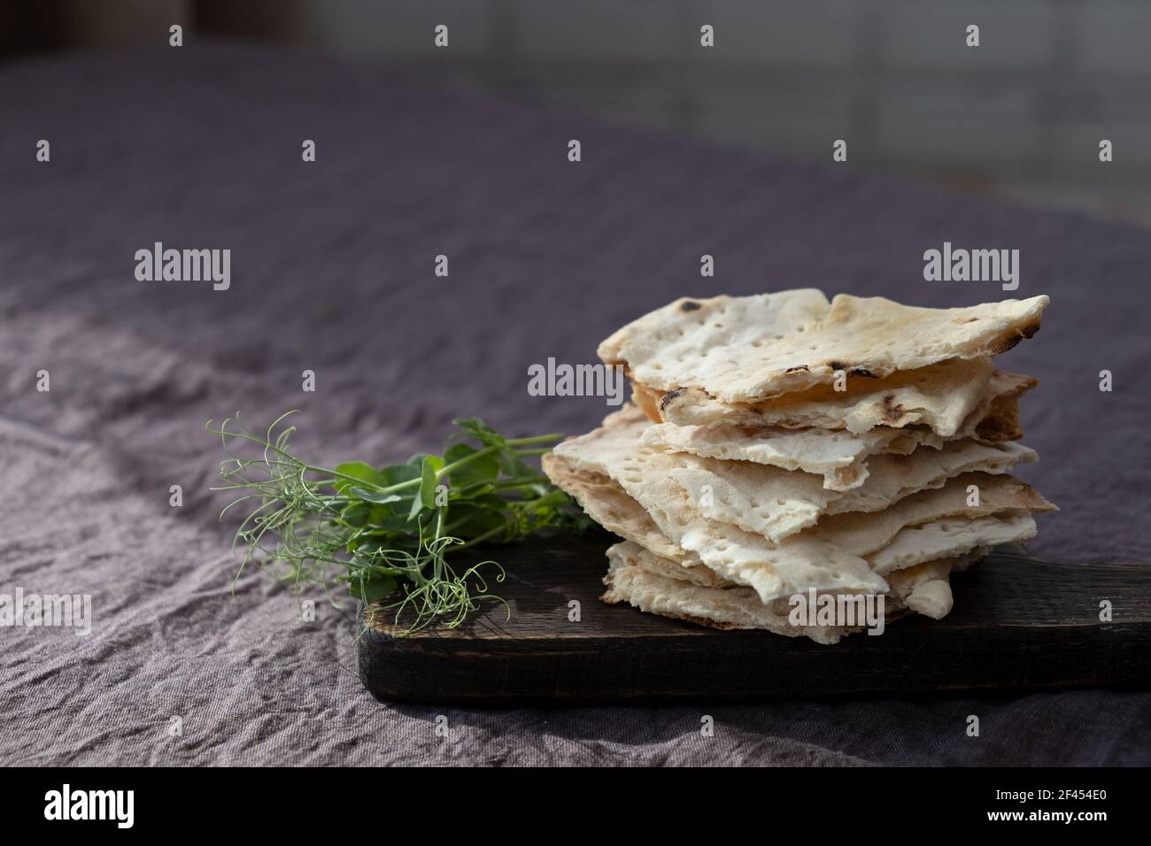 Homemade matzo with microgreen peas. Unleavened flatbread bread. Pesah celebration concept