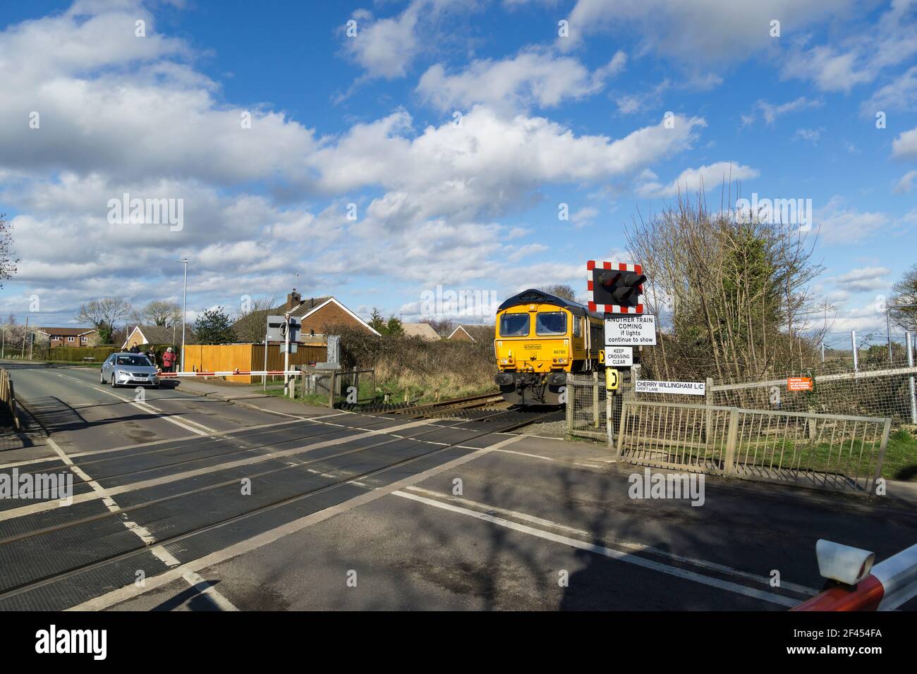 Gb railfreight train approaches croft lane level crossing cherry willingham hires stock