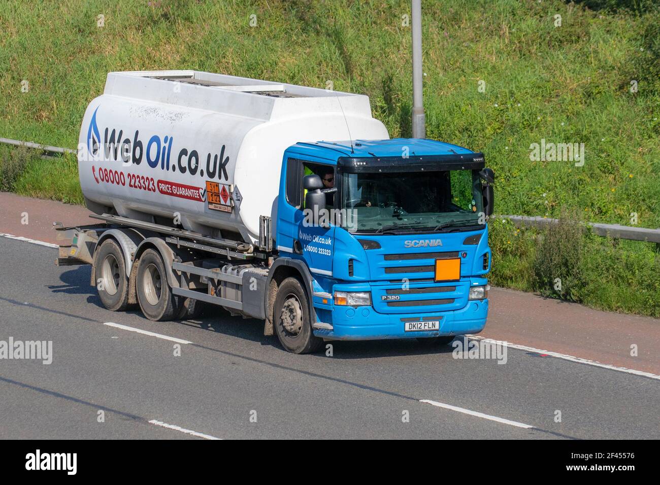 WebOil.com.uk heating oil trucks; Hazardous load haulage delivery trucks, lorry, heavy-duty vehicles, transportation, truck, cargo carrier, Scania P320 vehicle, European commercial transport industry HGV, M6 at Manchester, UK Stock Photo