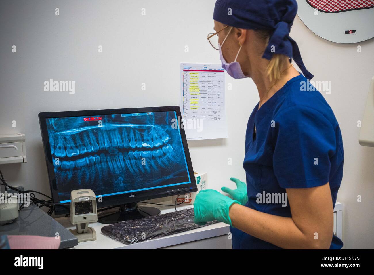 Dentist looking to x-ray on her computer Stock Photo