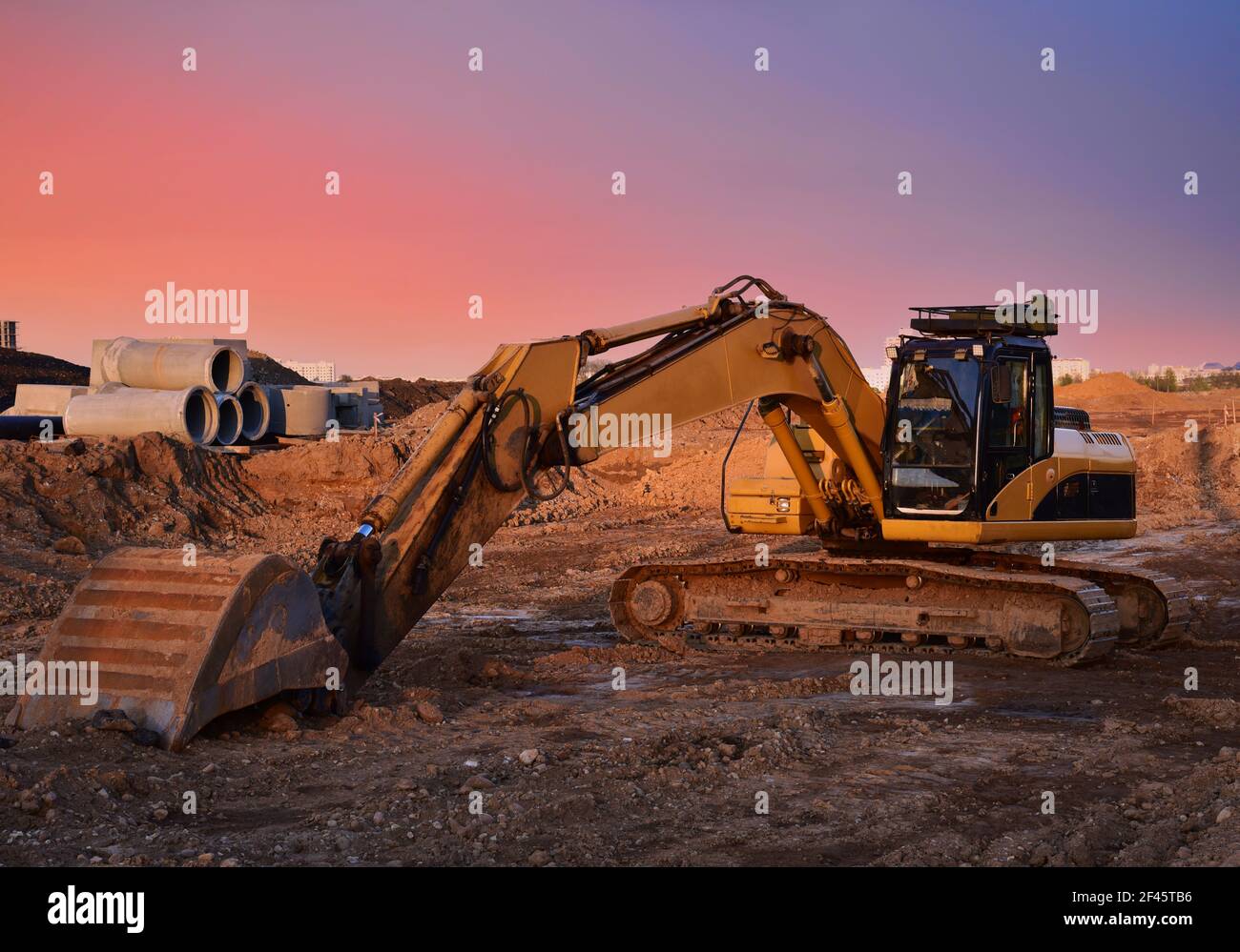 Excavator on earthworks at construction site on sunset backround ...