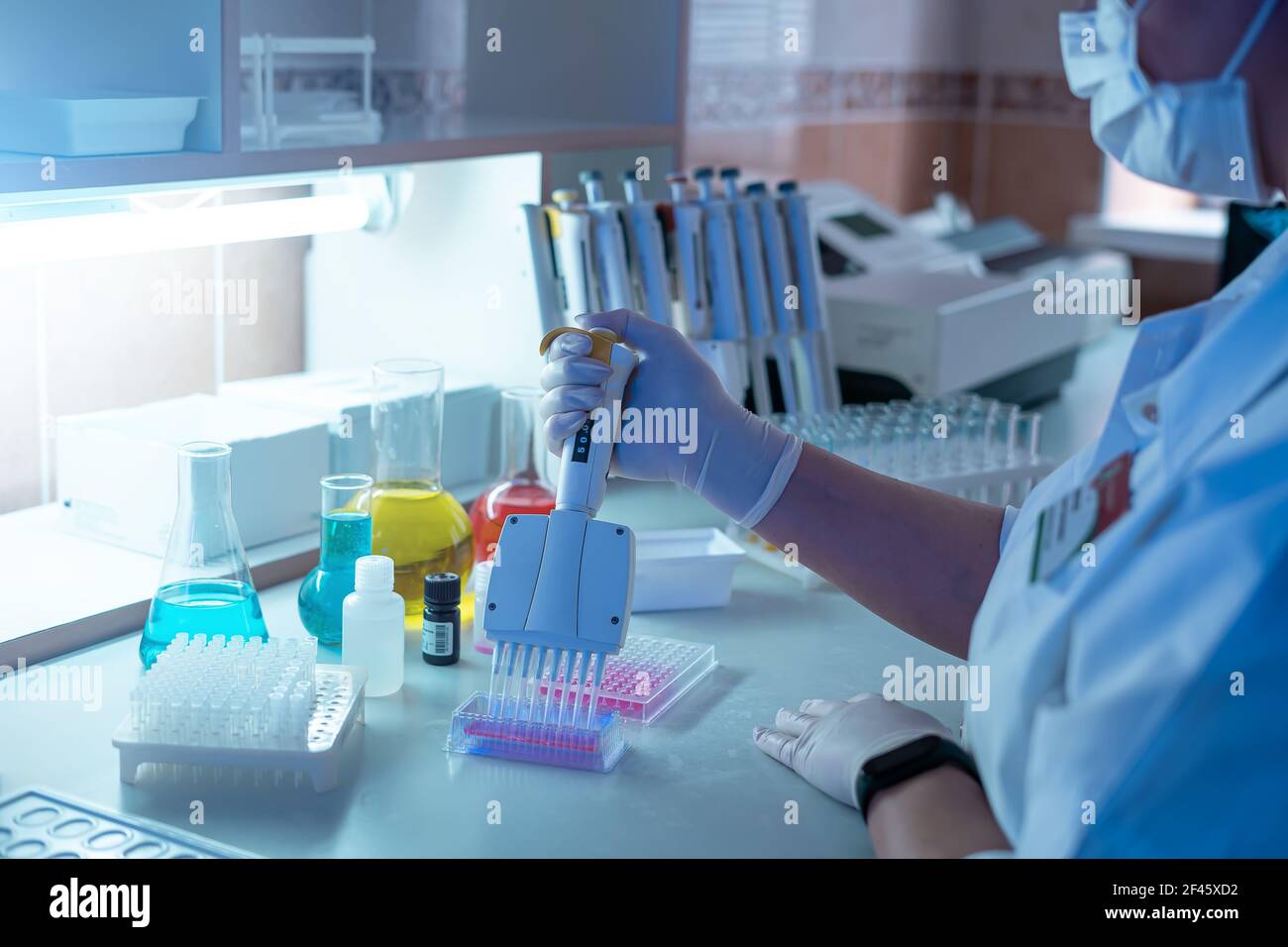 Woman scientist working in laboratory and examining biochemistry sample in test tube. Science technology research and development study concept. Stock Photo