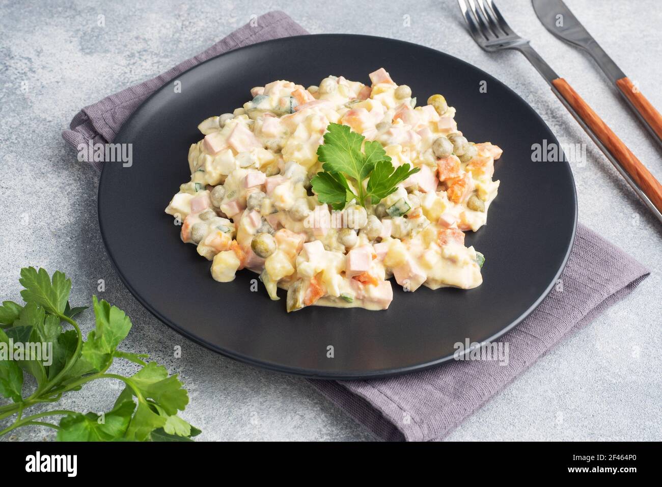 Olivier salad with mayonnaise on a plate. Russian is a traditional festive dish Stock Photo
