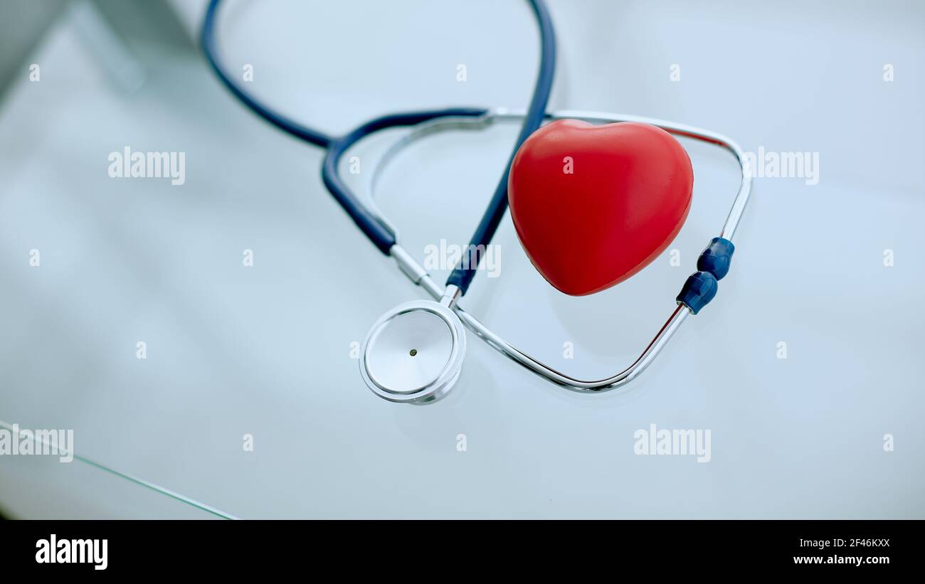phonendoscope and red heart on the table. Stock Photo