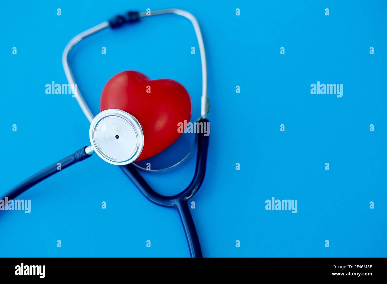 red heart and phonendoscope, isolated on a blue background. Stock Photo