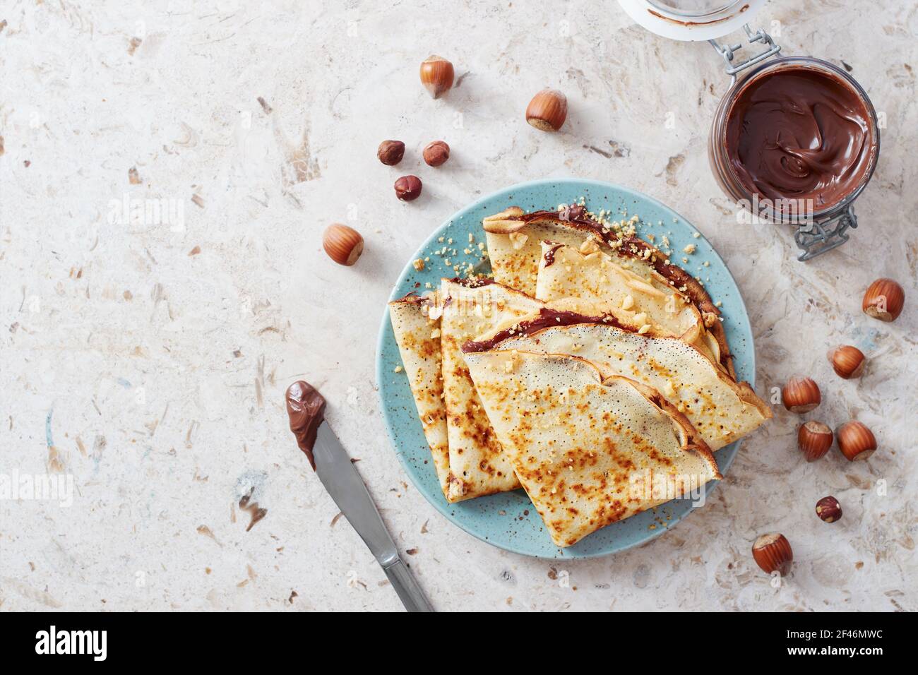 Homemade crepes, tasty thin pancakes with chocolate and nuts. Stock Photo