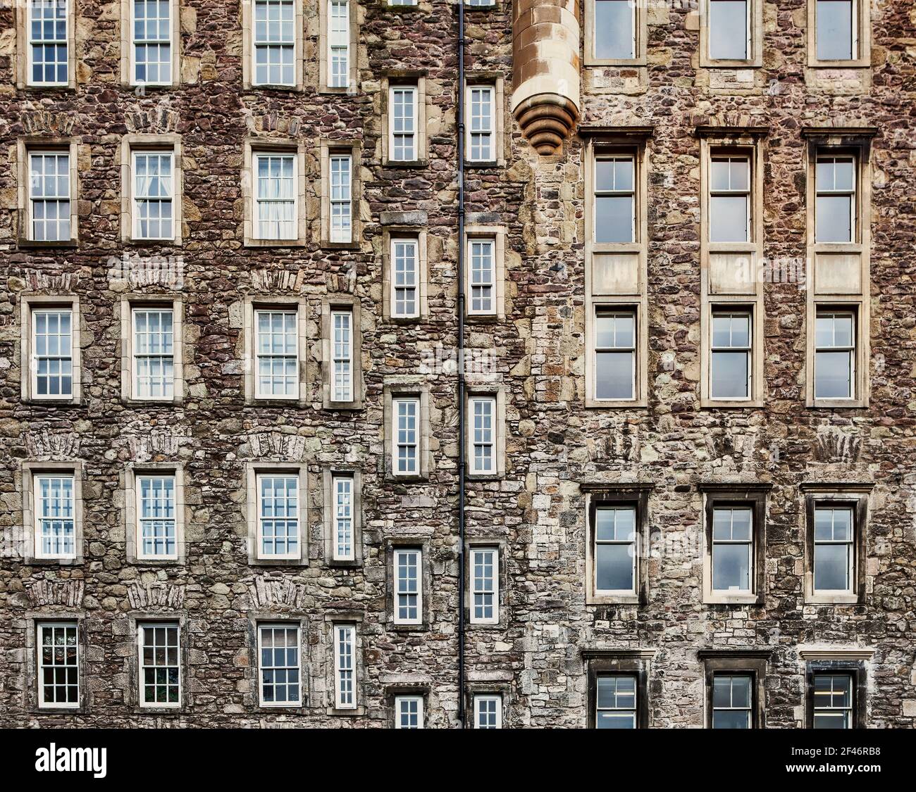 Many windows in a row on the facade of the urban historic building ...