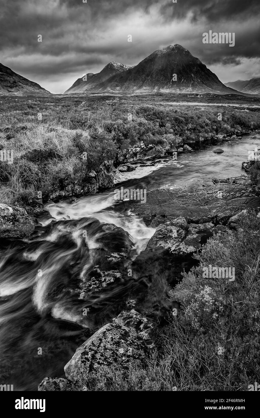 Epic  black and white dramatic landscape image of Buachaille Etive Mor and River Etive in Scottish Highlands on a Winter morning with moody sky and li Stock Photo