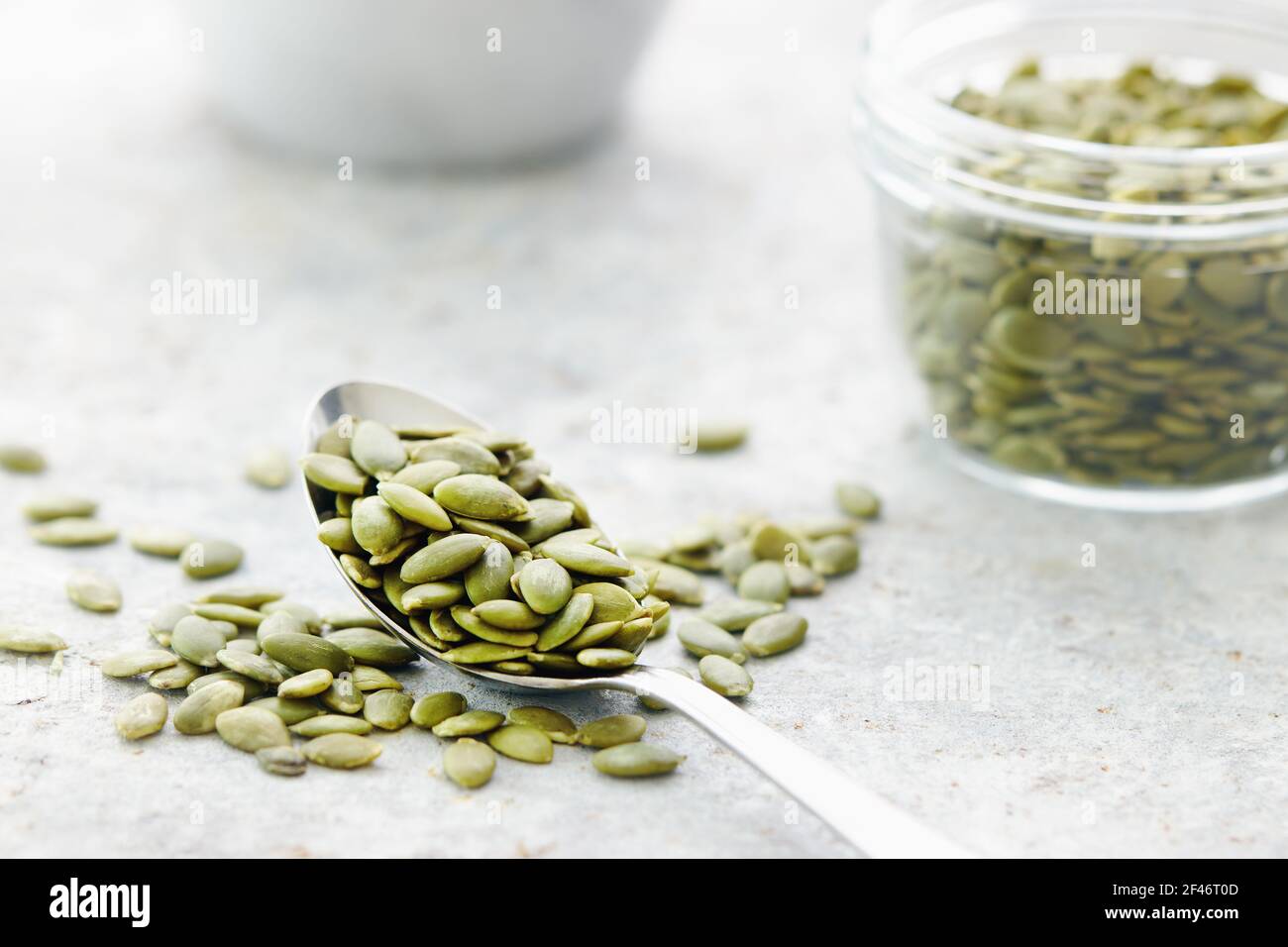 Pumpkin seeds on and beside spoon, close up Stock Photo