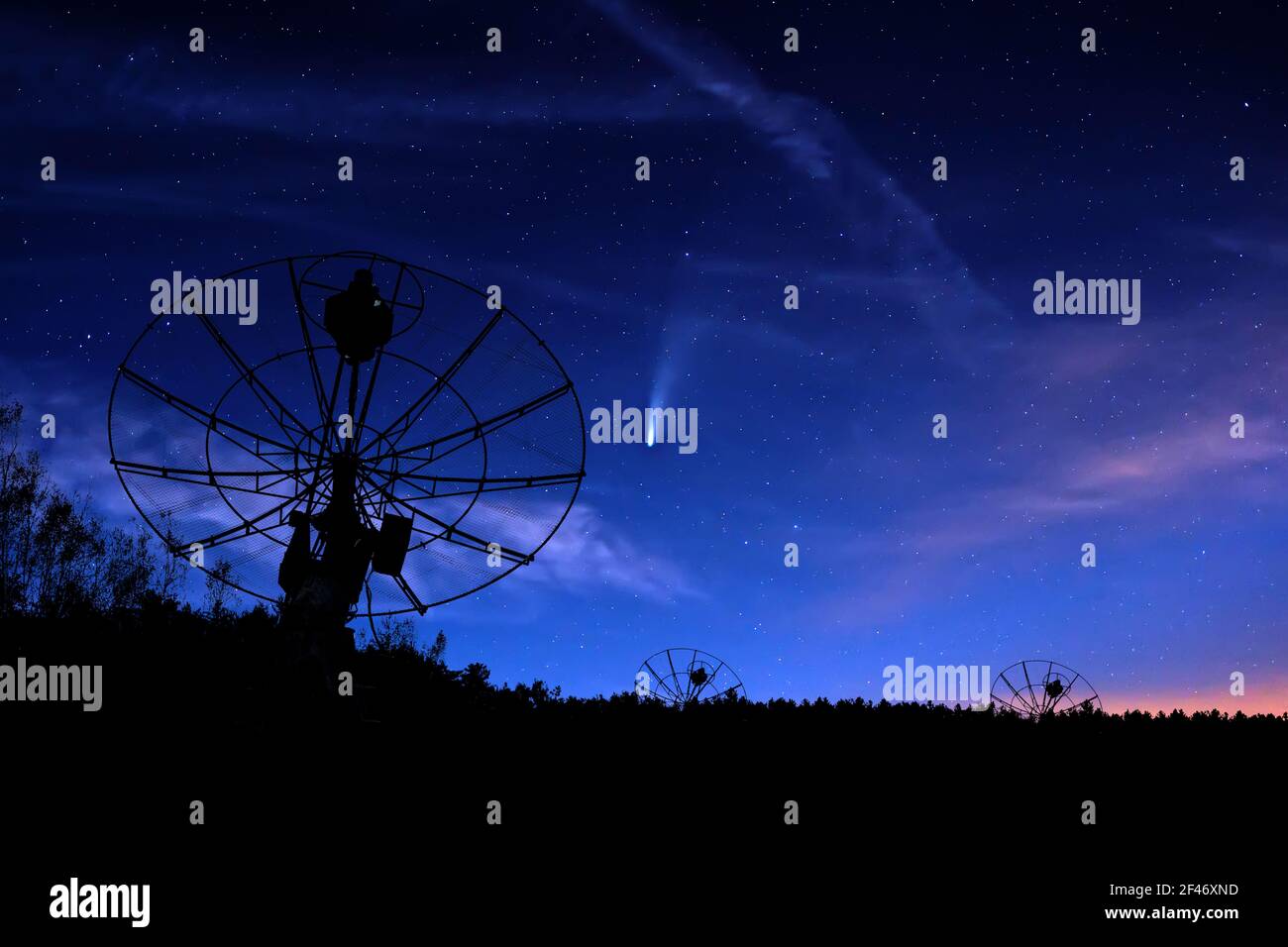 radiotelescopes silhouettes under night starry cloudy sky background Stock Photo