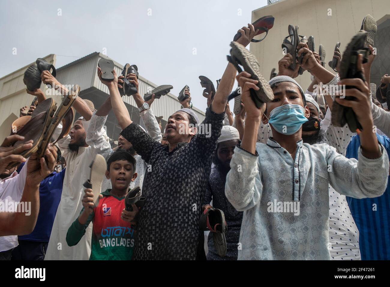 Dhaka, Bangladesh. 19th Mar, 2021. Protesters chant slogans while holding footwears during the protest.Bangladeshis raise their footwear and shout slogans during a protest after Friday prayers, against the visit of Indian Prime Minister Narendra Modi in Dhaka, Bangladesh, Modi is expected to visit Bangladesh on 26 march to attend the 50th anniversary of Independence Day of Bangladesh as well as the 100th birth anniversary of the country's first president Sheikh Mujibur Rahman. (Photo by Sazzad Hossain/SOPA Images/Sipa USA) Credit: Sipa USA/Alamy Live News Stock Photo