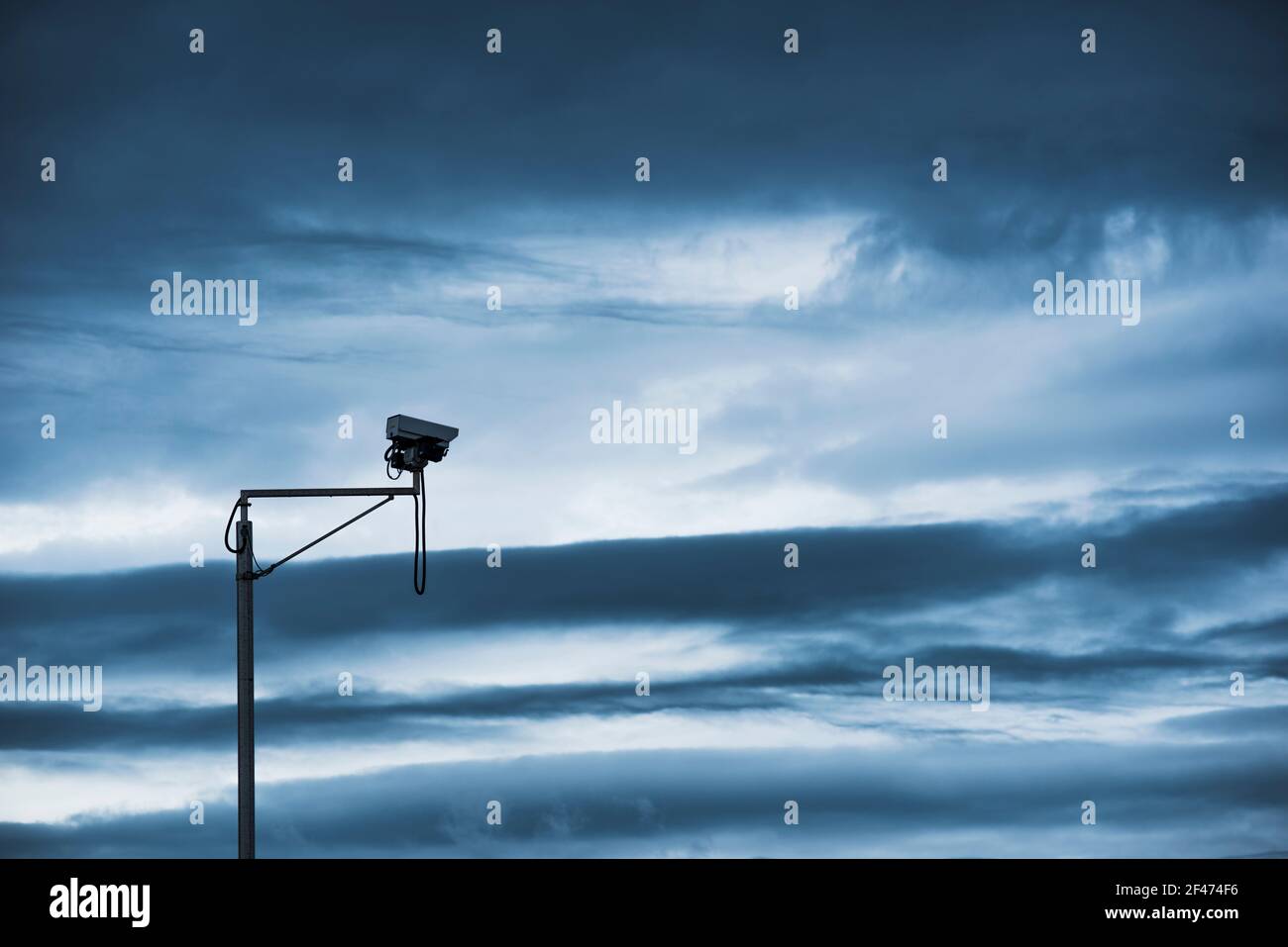 Security camera against a dark, moody sky Stock Photo