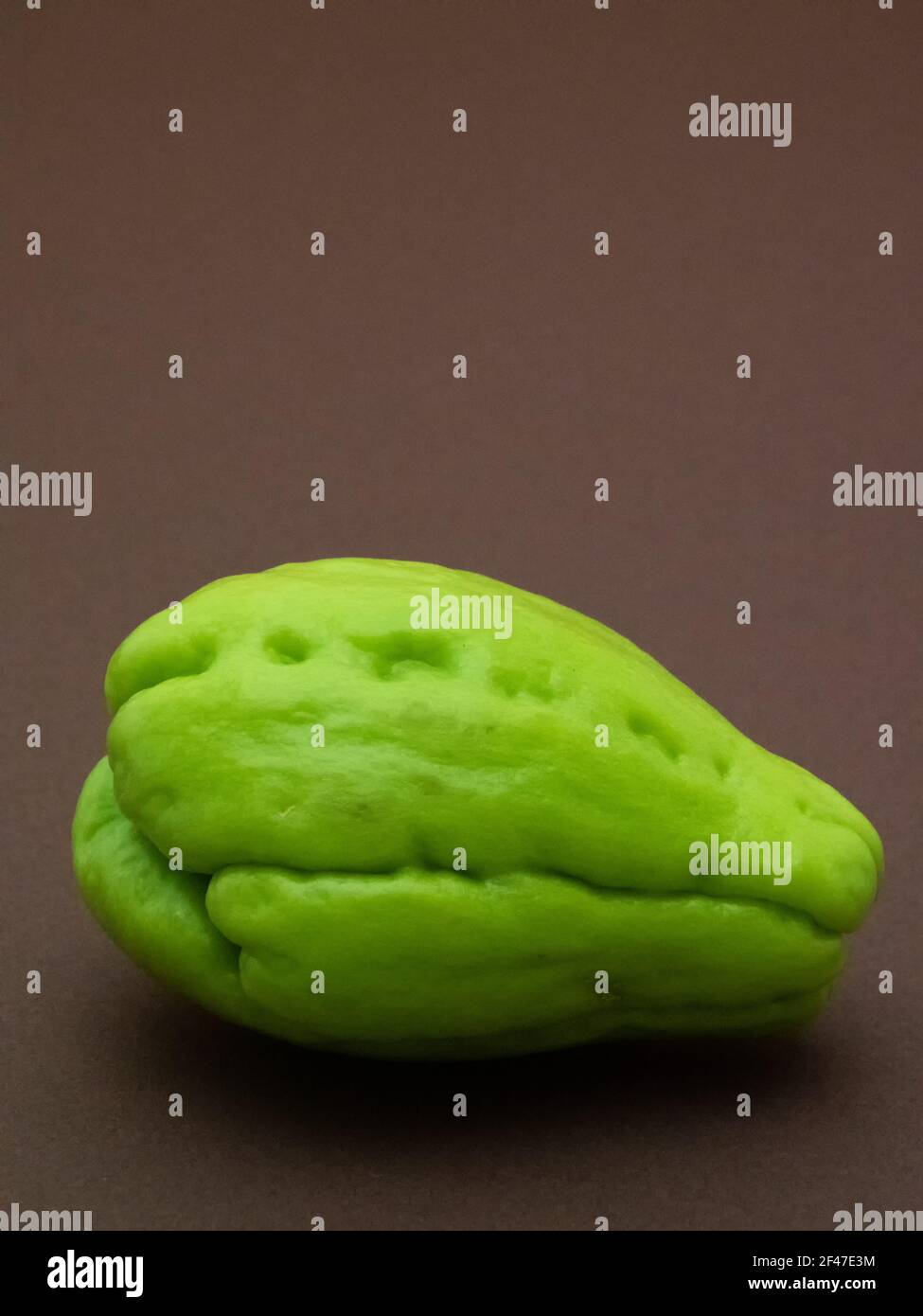Chayote fruit isolated on brown background Stock Photo