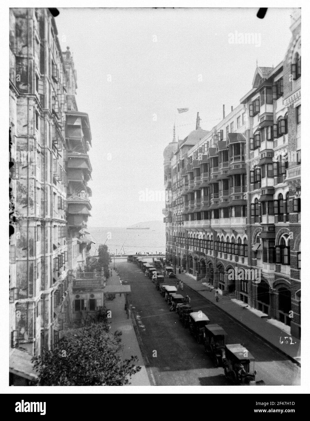 Bombay (India). Road escape with parked automobiles and Taj-Mahal hotel. View to the high-sea passenger steamer 'Cleveland Stock Photo