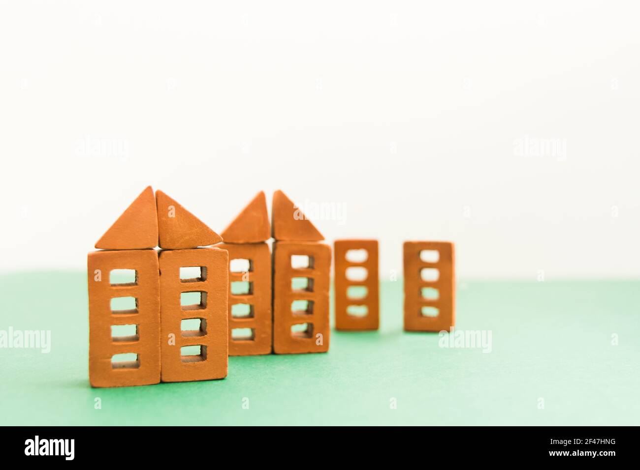 Miniature Brick Block Toy house on green background Stock Photo