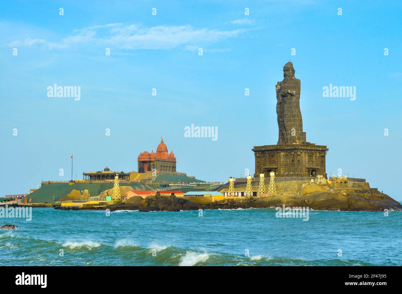 The Vivekananda Rock Memorial surrounded by the sea under a blue sk ...