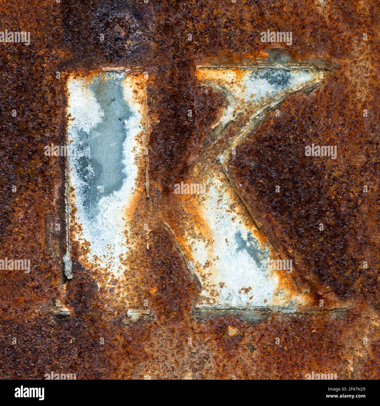 Remains of the letter K on rusty metal plate Stock Photo