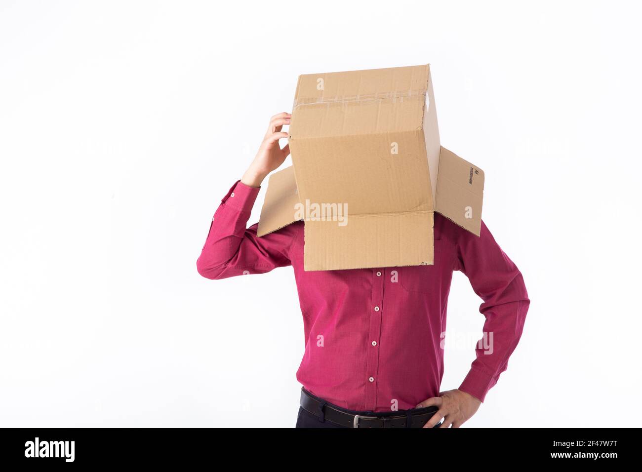man in a red shirt with a cardboard box on his head makes a gesture ...