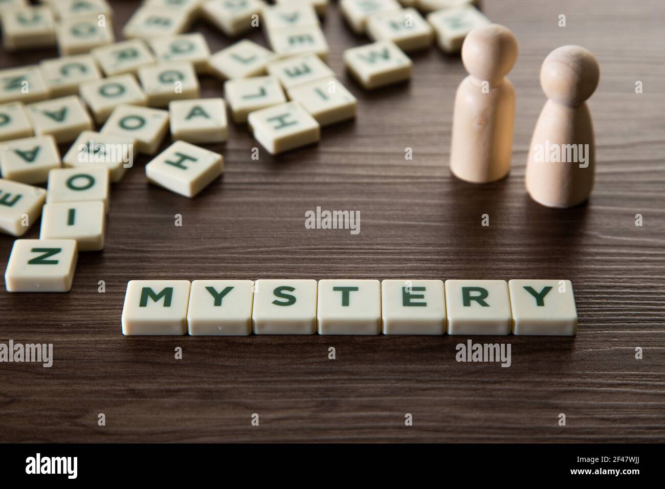 Alphabet block with Mystery word wooden table. Mystery concept. Stock Photo