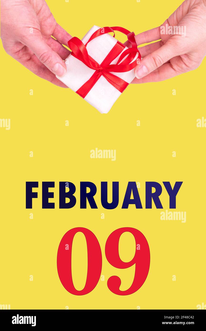 February 9th. Festive Vertical Calendar With Hands Holding White Gift Box  With Red Ribbon And Calendar Date 9 February On Illuminating Yellow  Backgrou Stock Photo - Alamy