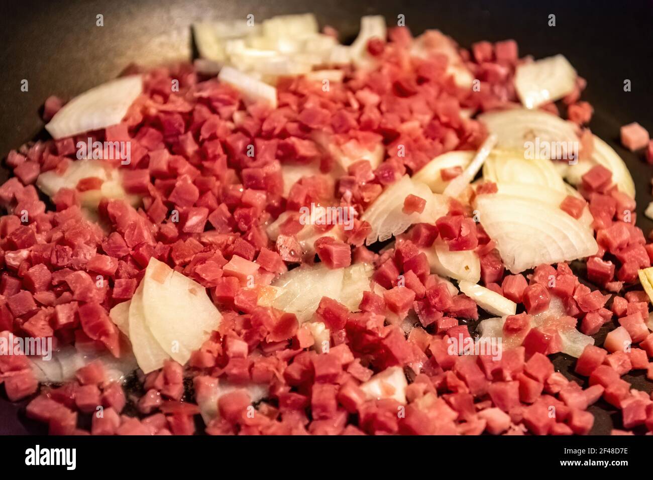 A closeup shot of sliced meats with onion on the pan Stock Photo