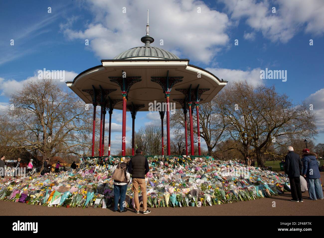 London, UK, 19 March 2021: Clapham Common bandstand and the surrounding trees and benches are home to an ever-growing shrine of flowers, candles and messages in memory of Sarah Everard. Some are personal and sad, others are angry and speak of the high numbers of women killed each year by men. Last week the Metropolitan Police broke up a vigil at the site. Anna Watson/Alamy Live News Stock Photo