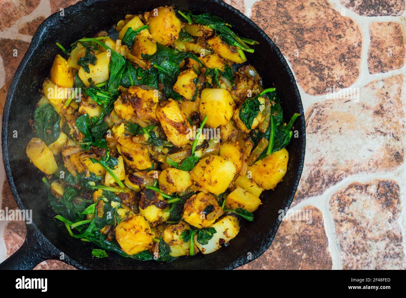 Saag Aloo, Indian style spinach and potatoes in cast iron pan Stock