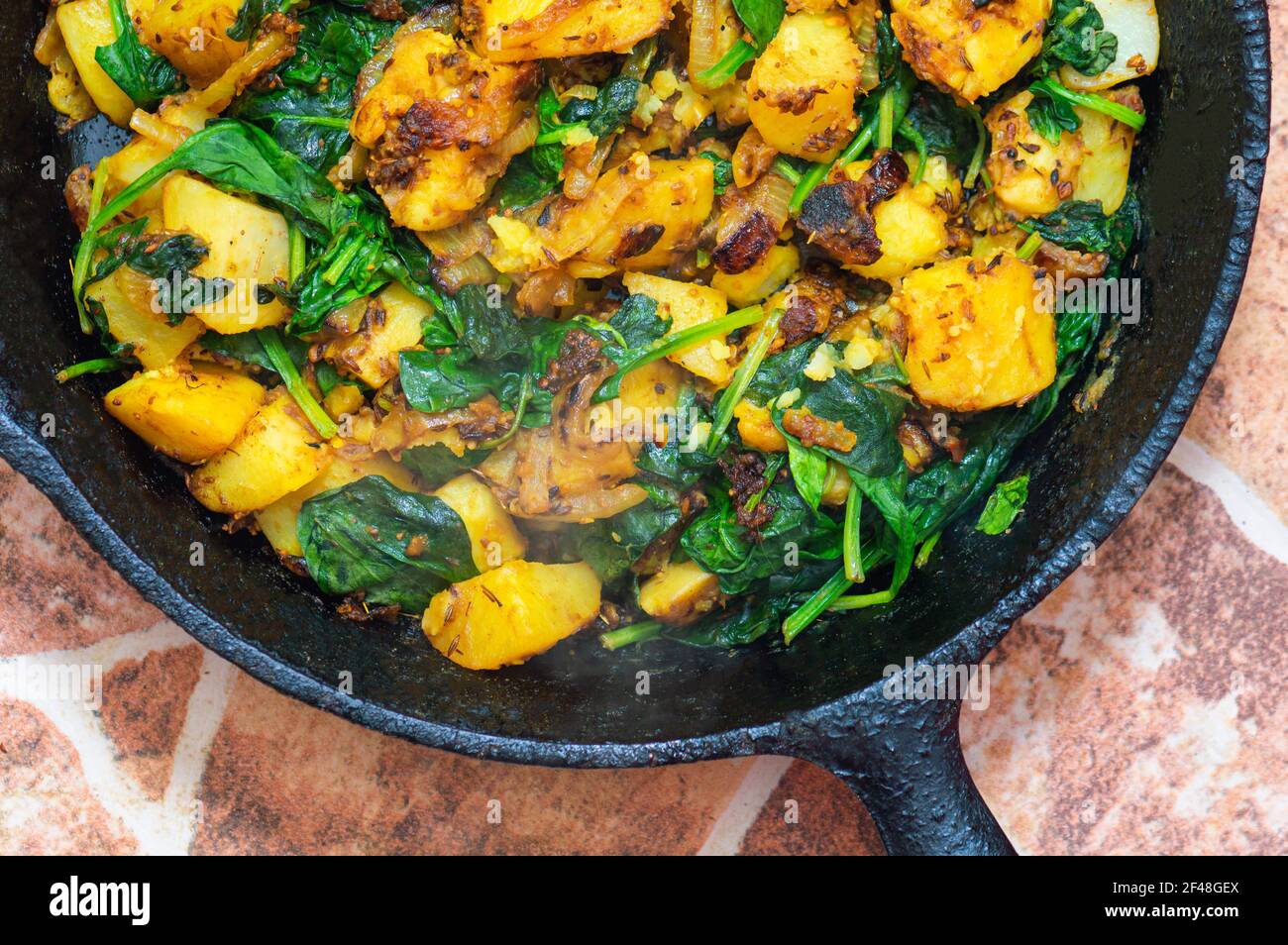 Saag Aloo, Indian style spinach and potatoes in cast iron pan Stock