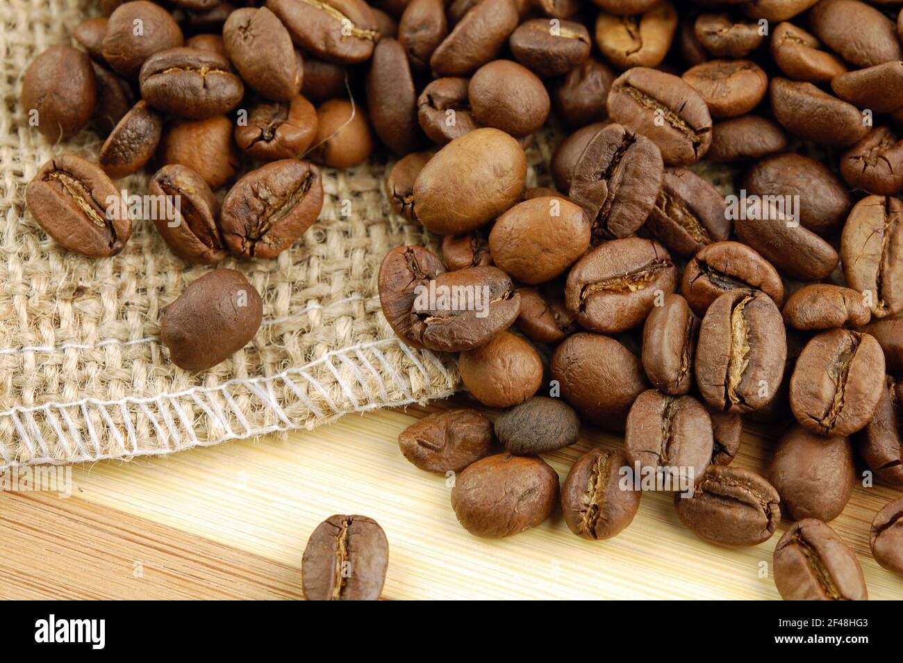 Coffee beans on sacking bag on desk. Stock Photo