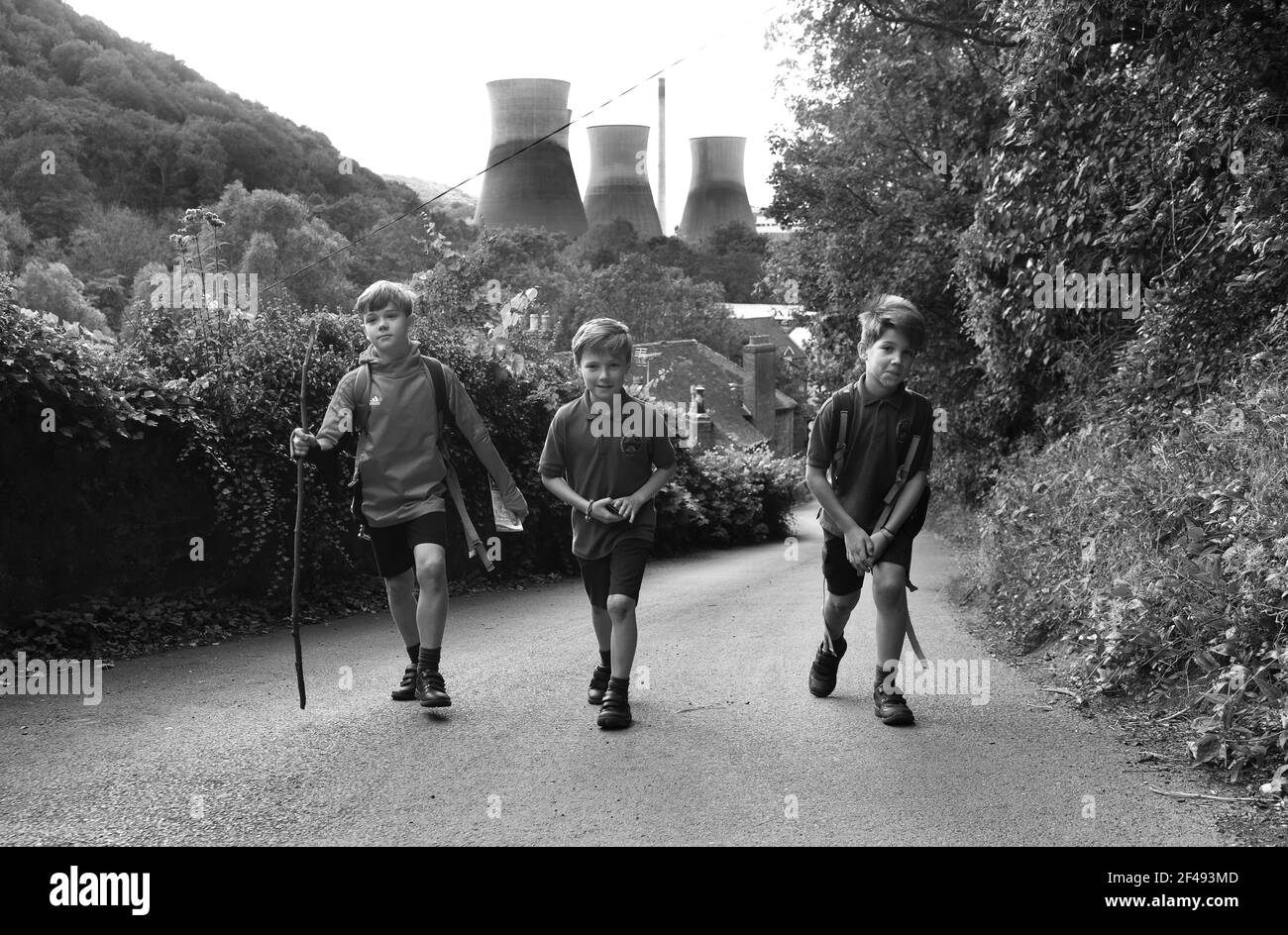 Walking home from school boys walking up steep Hill after a school day. pupils children walk home steep hill Britain Uk. PICTURE BY DAVID BAGNALL Stock Photo