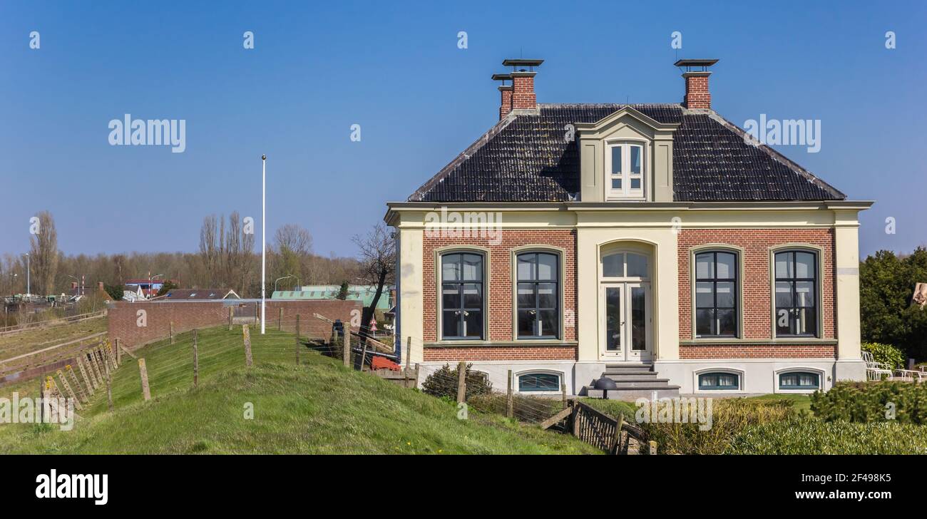 Panorama of a historic house behind the dike in Zoutkamp, Netherlands Stock Photo