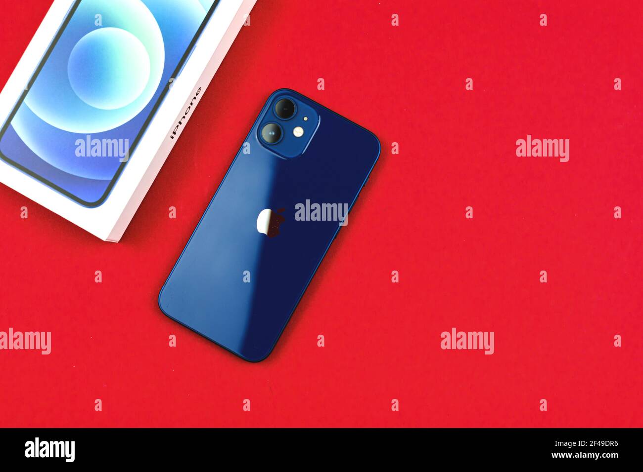 Kharkov, Ukraine - March 12, 2021: Backside of iPhone 12 Paciffic Blue color on red table or background Stock Photo