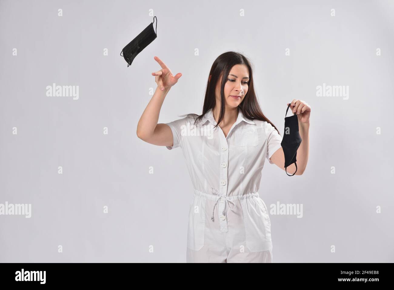 Woman throws away disposable face mask and chooses reusable mask, ecology care concept Stock Photo