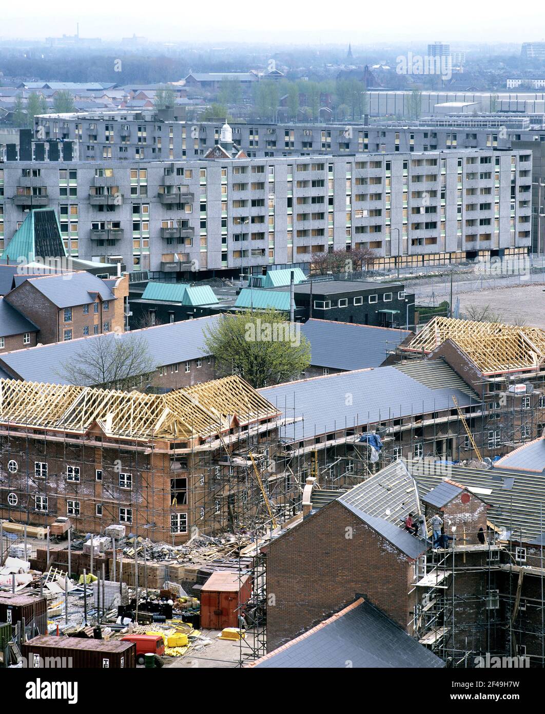 New housing association houses being built in Hulme, Manchester, with some of the 1970s Hulme Crescents behind, boarded up prior to demolition. Stock Photo