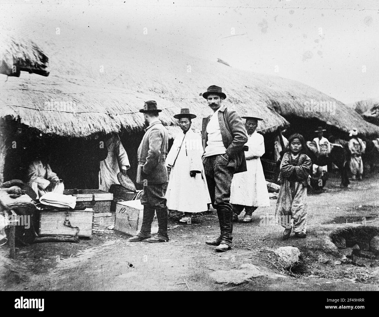 Expedition leader Bruno Bone Hauer with his brother-in-law Richard  Zimmermann (center) during a stay in a Korean village. On the ground  transport boxes for the pony caravan Stock Photo - Alamy