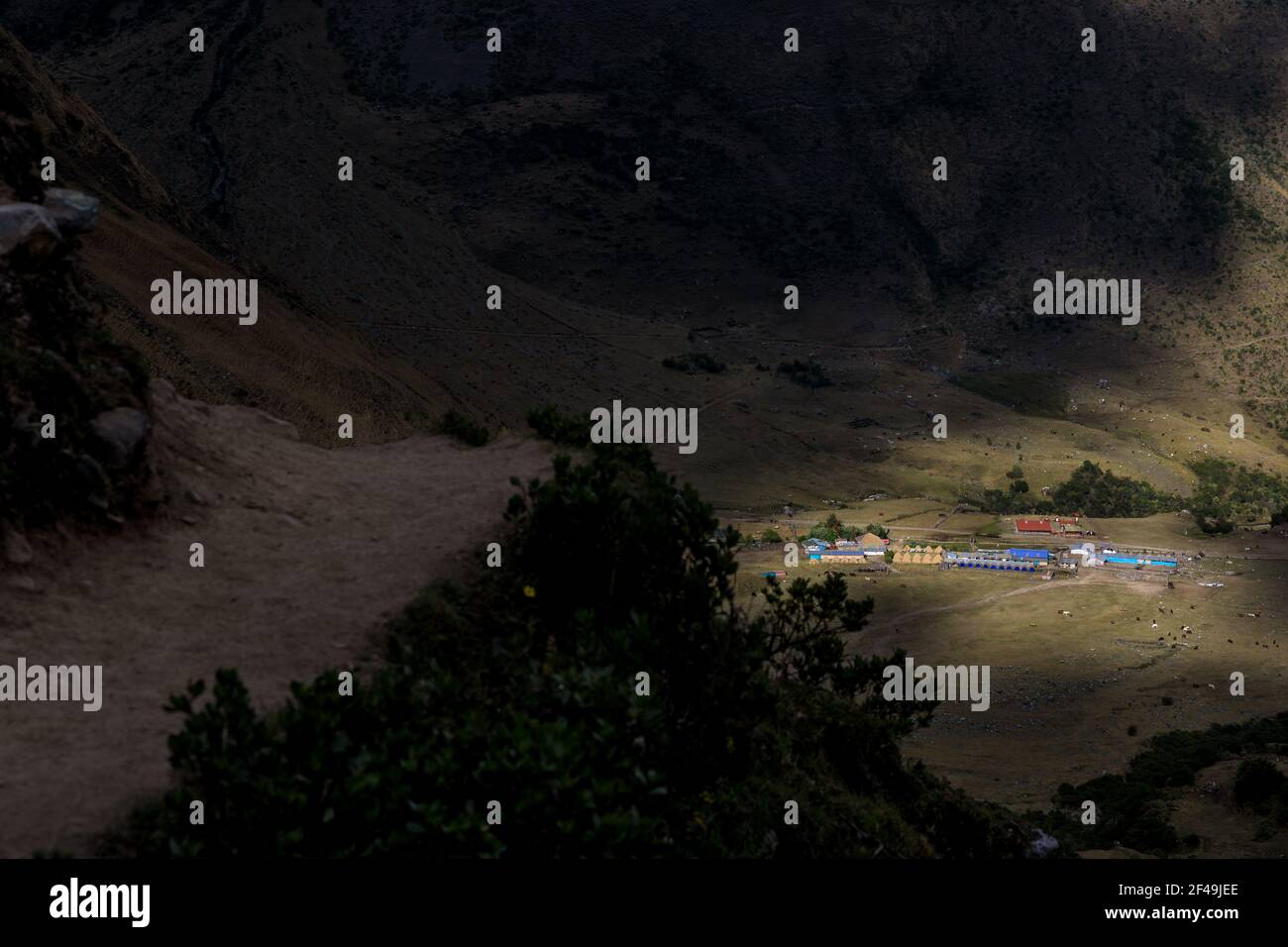 Warm, sunny light falling over the Salkantaypampa camp seen from the trail leading to Humantay lake on the Salktantay trek in Peru. Adventure trekking Stock Photo