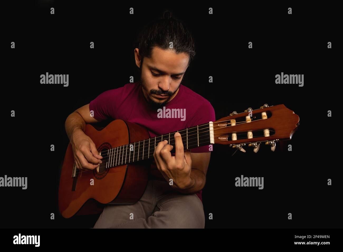 Man playing an acoustic guitar with black background Stock Photo