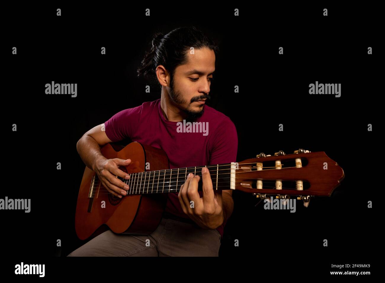 Man playing an acoustic guitar with black background Stock Photo