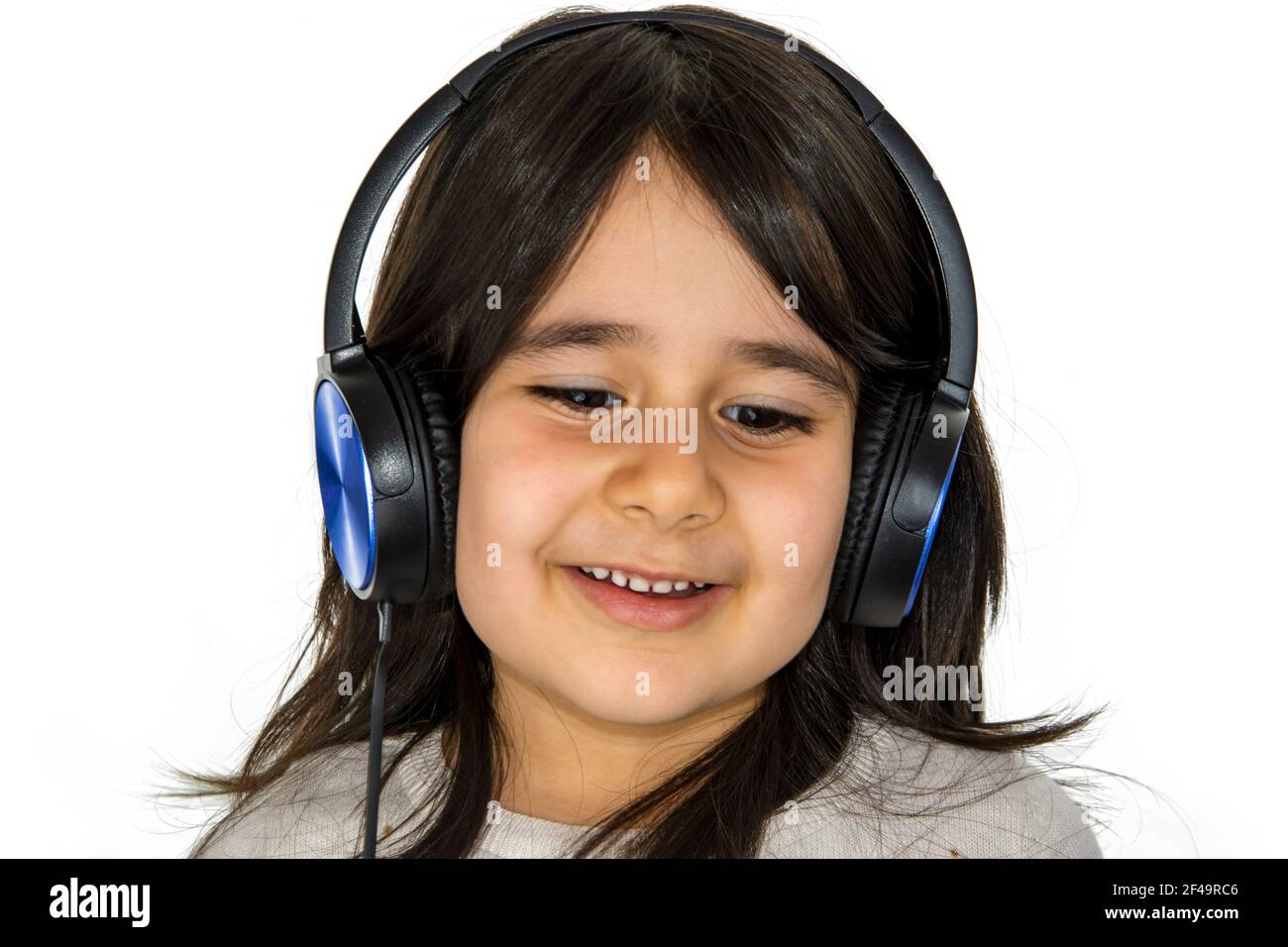 Smiling little girl with headphones looking on white background Stock ...