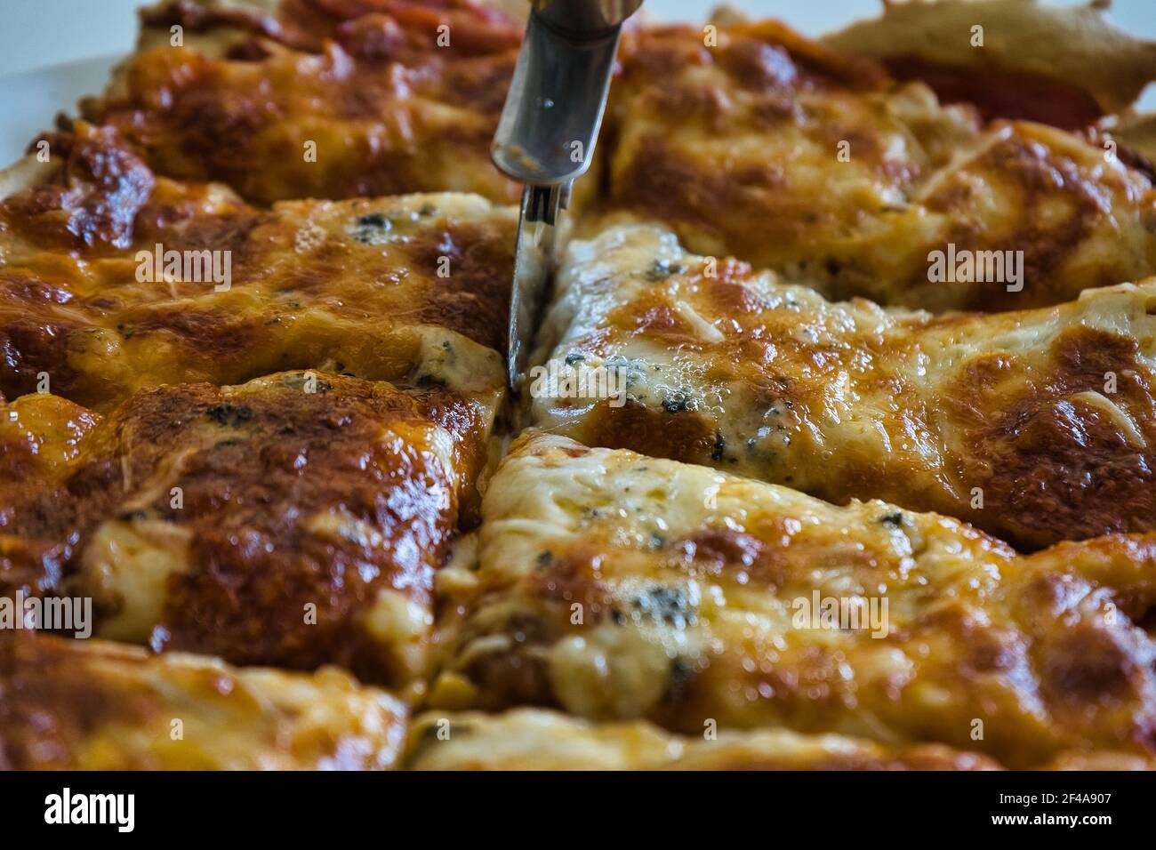 Delicious homemade hot Italian pizza ready to eat. With tomato, ham, mozzarella cheese and four cheeses. Taste Stock Photo