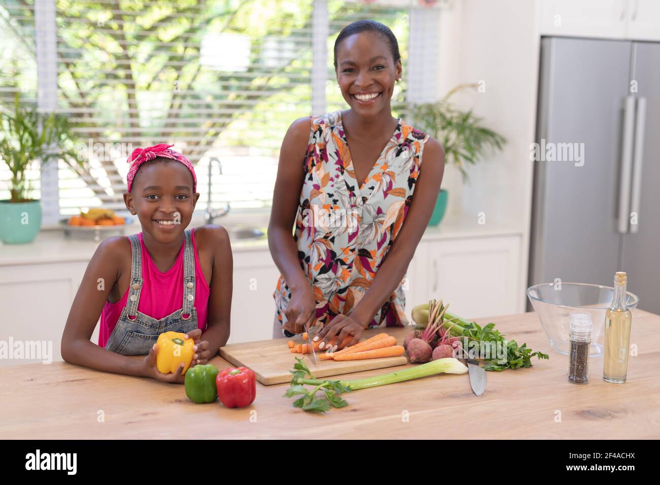 Portrait of happy african american mother teaching daughter cooking in the kitchen Stock Photo