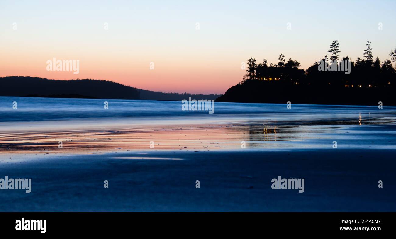 A beach sunset with water reflection near Tofino British Columbia Canada during spring break. Stock Photo