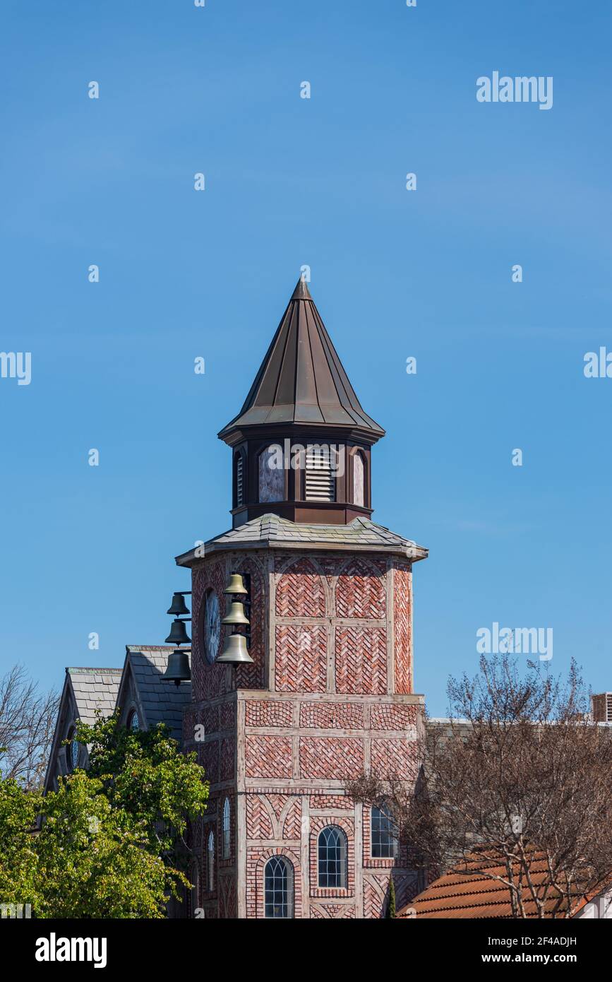 Brick building with tower and steeple against a blue sky. Stock Photo